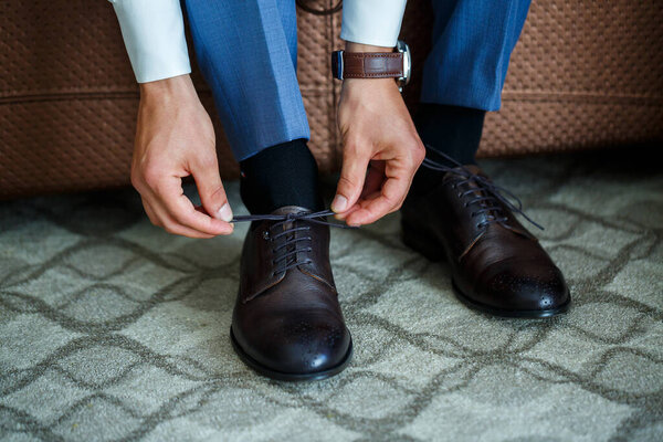man puts on a suit on the wedding day