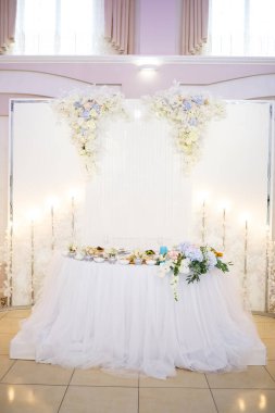 Güzel süslemeleri olan yeni evliler için düğün masası.