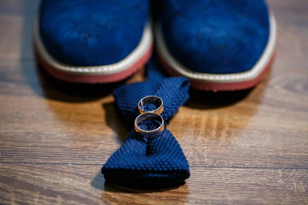 Złote Obrączki Nowożeńców Leżą Obok Męskich Butów Dla Pana Młodego — Zdjęcie stockowe