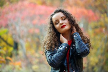 Sonbahar parkında bukleli güzel bir kız.