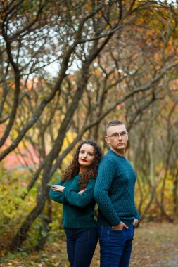 Sonbahar parkında kazaklı bir çift.