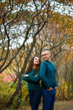 Sonbahar parkında kazaklı bir çift.