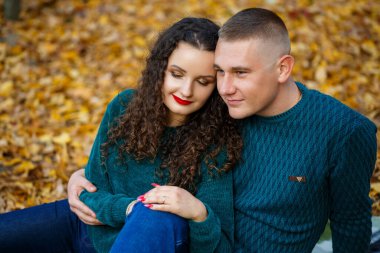 Sonbahar parkında kazaklı bir çift.