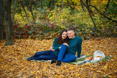 Sonbahar parkında kazaklı bir çift.