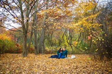 Sonbahar parkında kazaklı bir çift.