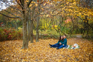 Sonbahar parkında kazaklı bir çift.
