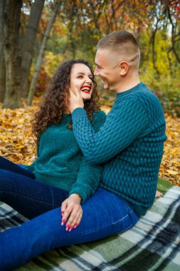 Sonbahar parkında kazaklı bir çift.