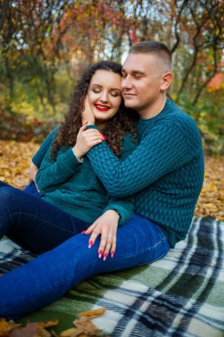 Sonbahar parkında kazaklı bir çift.