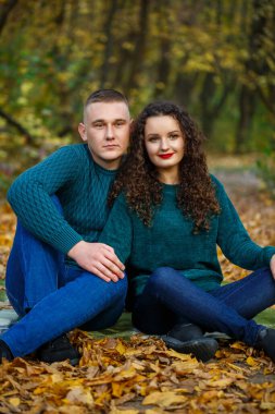 Sonbahar parkında kazaklı bir çift.