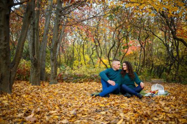 Sonbahar parkında kazaklı bir çift.