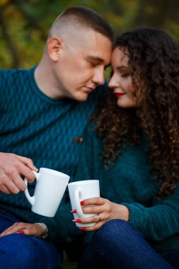 Kazaklı bir çift sonbahar ormanında çay içer.