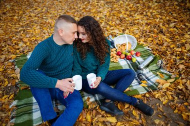 Kazaklı bir çift sonbahar ormanında çay içer.