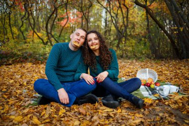 Bir adam ve bir kız sonbahar ormanında kurabiyelerle