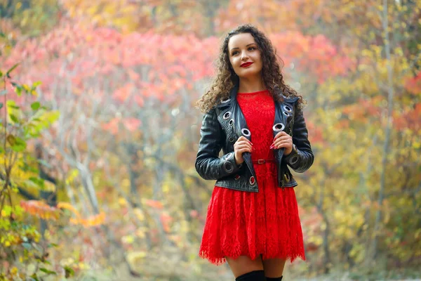 Sonbahar parkında bukleli güzel bir kız.