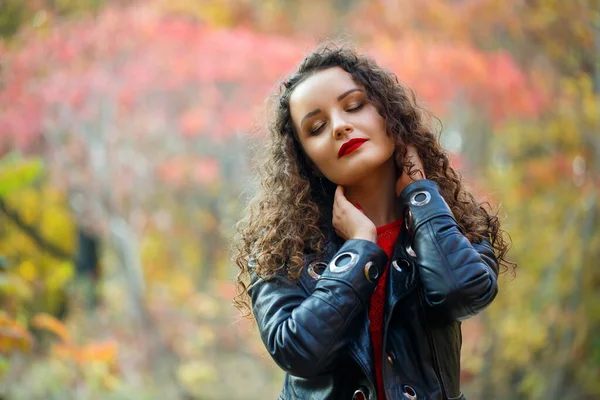 Sonbahar parkında bukleli güzel bir kız.