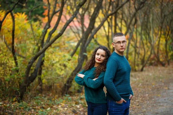 Sonbahar parkında kazaklı bir çift.