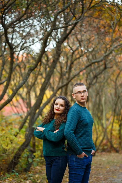 Sonbahar parkında kazaklı bir çift.