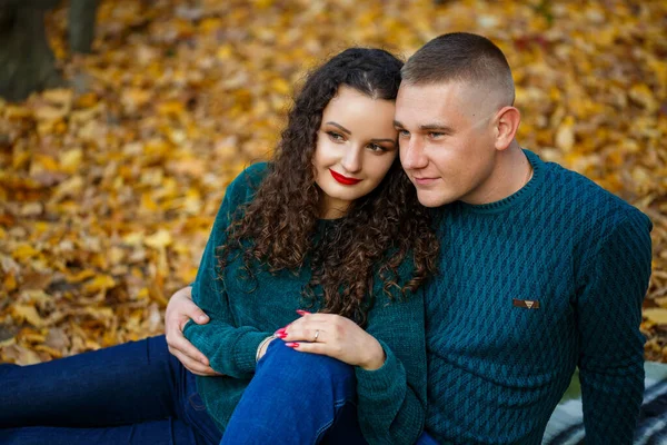 Sonbahar parkında kazaklı bir çift.