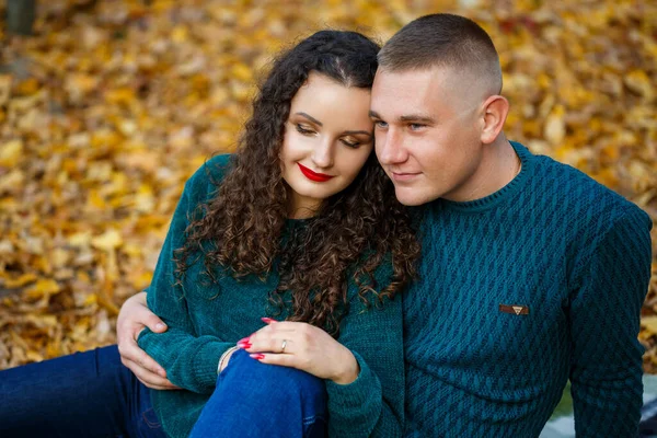 Sonbahar parkında kazaklı bir çift.