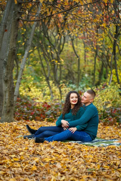 Sonbahar parkında kazaklı bir çift.