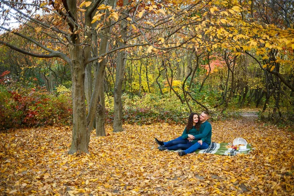 Sonbahar parkında kazaklı bir çift.