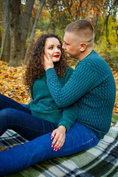 Sonbahar parkında kazaklı bir çift.