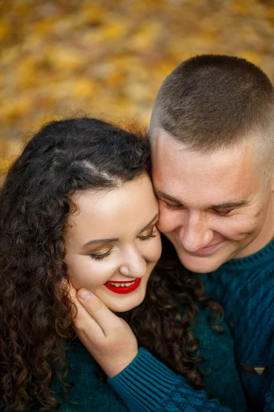 Sonbahar parkında kazaklı bir çift.