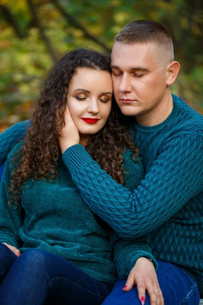 Sonbahar parkında kazaklı bir çift.