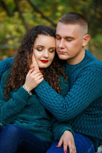 Sonbahar parkında kazaklı bir çift.