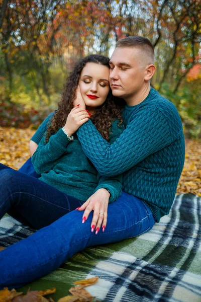 Sonbahar parkında kazaklı bir çift.