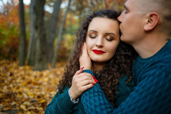 Sonbahar parkında kazaklı bir çift.