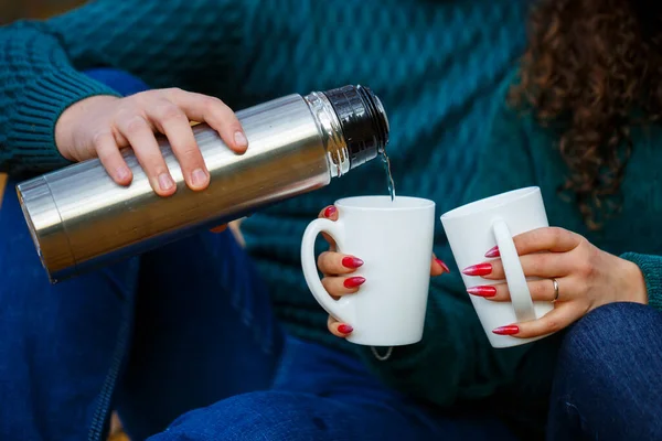 Kazaklı bir çift sonbahar ormanında çay içer.