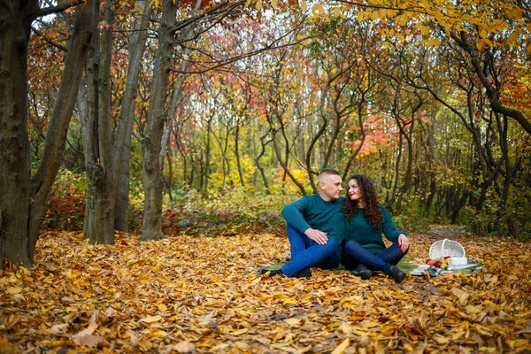 Sonbahar parkında kazaklı bir çift.