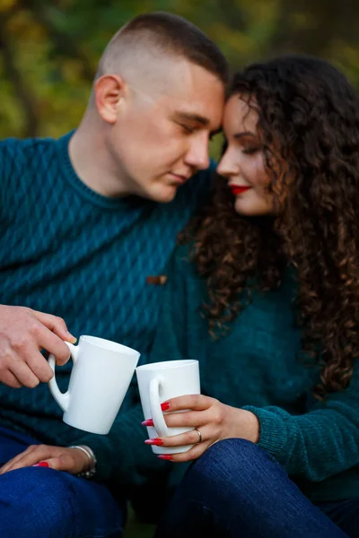 Kazaklı bir çift sonbahar ormanında çay içer.