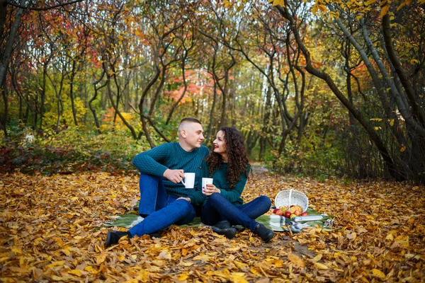 Kazaklı bir çift sonbahar ormanında çay içer.