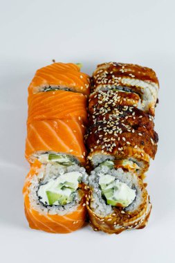 Suşi çeşitleri. Avokado ve salatalıklı suşi. Somon ve havyarlı suşi. Ton balığı ve havyarlı suşi. Hafif bir arkaplanda. Japon yemeği. Yukarıdan görüntüle