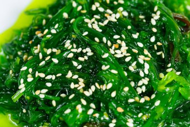 Beyaz arka planda izole edilmiş Asya yosunları. Hiashi Wakame salatası.