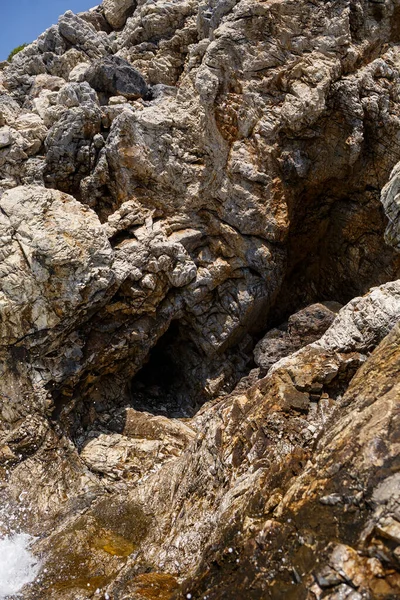 Mavi Akdeniz 'in harika manzarası. Güneşli kayalar, köpüklü dalgalar ve su sıçraması. Dalga kıyıdaki kayalara çarpar.