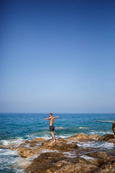 Ένας Νεαρός Άνδρας Στέκεται Στους Βράχους Θέα Την Ανοιχτή Μεσόγειο — Φωτογραφία Αρχείου