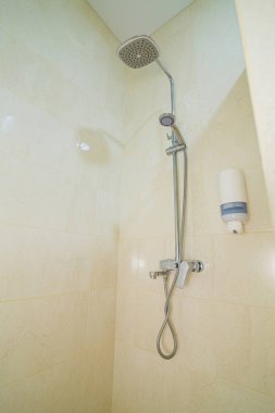 Duşlu, duşlu, fayanslı parlak bir banyo.