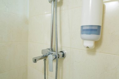 Duşlu, duşlu, fayanslı parlak bir banyo.