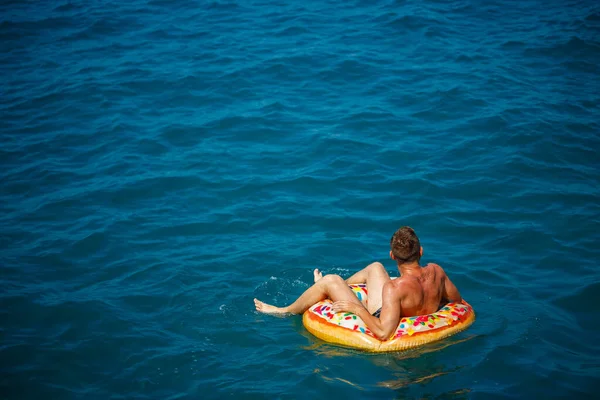 Ein Junger Mann Schwimmt Einem Sonnigen Tag Auf Einem Aufblasbaren — Stockfoto