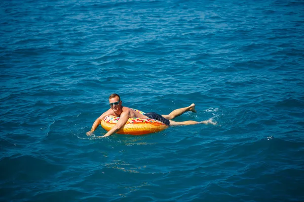Genç Bir Adam Mavi Suyla Denizde Şişirilebilir Bir Halka Üzerinde — Stok fotoğraf