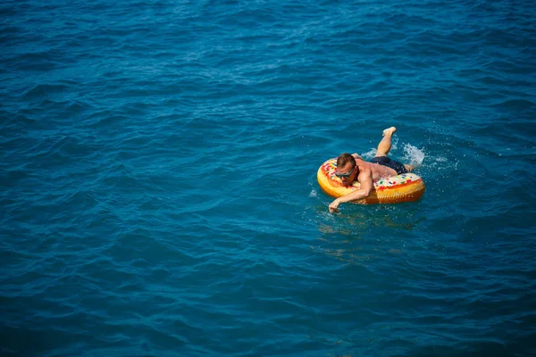 Een Jongeman Drijft Een Opblaasbare Luchtring Zee Met Blauw Water — Stockfoto