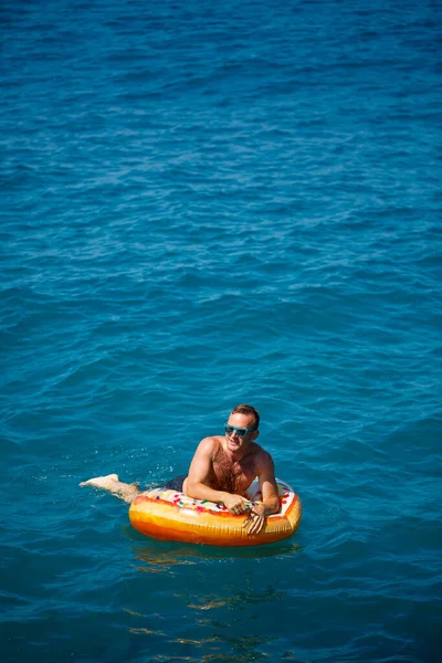 Jongeman Een Opblaasbare Ring Zee Rustend Zwemmend Een Zonnige Dag — Stockfoto