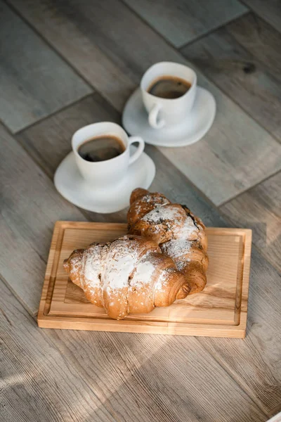 新鲜的糕点羊角面包 上面有巧克力和两杯黑咖啡 浪漫的早餐 — 图库照片