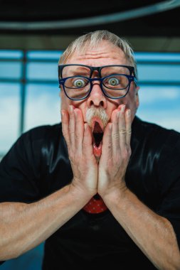 Şok olmuş gözlüklü bir adam komik bir an yakalıyor, yaratıcı projeler için mükemmel abartılı duygulara ihtiyaç duyan sahneler ve anlatılar içindeki coşkuyu artırmak için.