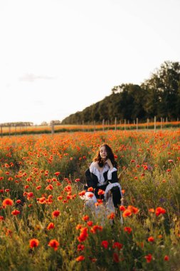 Haşhaş tarlasında çekilen huzurlu bir an, güneşin sıcacık parıltısı altında doğanın güzelliğini gösteren bir kadın, huzur ve sükunet için mükemmel..