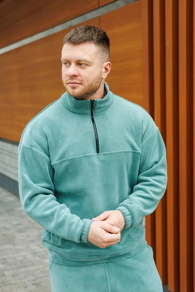 Genç bir adam modaya uygun bir kazakla poz veriyor. Gündelik geziler ve modern sokak kıyafetleri modasının en son modellerini sergiliyor.