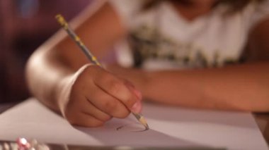 çocuğun eli kağıt üzerine bir kalem çizer.lose-up.